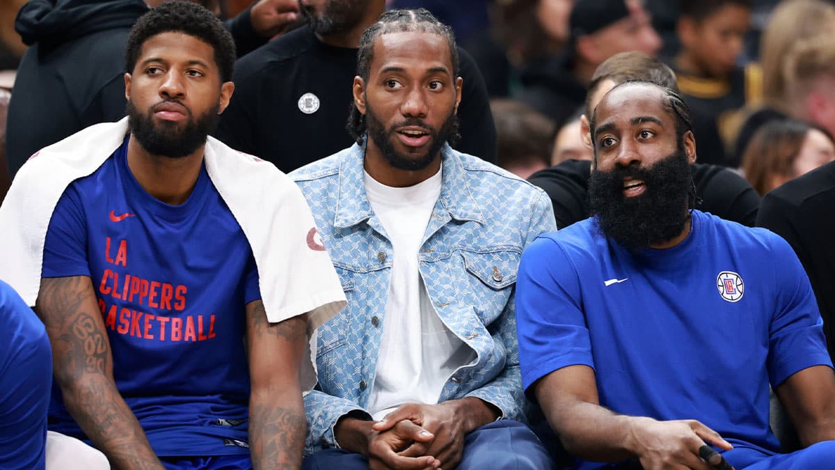 os Angeles Clippers forward Paul George (13, left) and forward Kawhi Leonard (2, center) and guard James Harden (1, right) watch the game from the bench during the third quarter against the Utah Jazz at Crypto.com Arena.