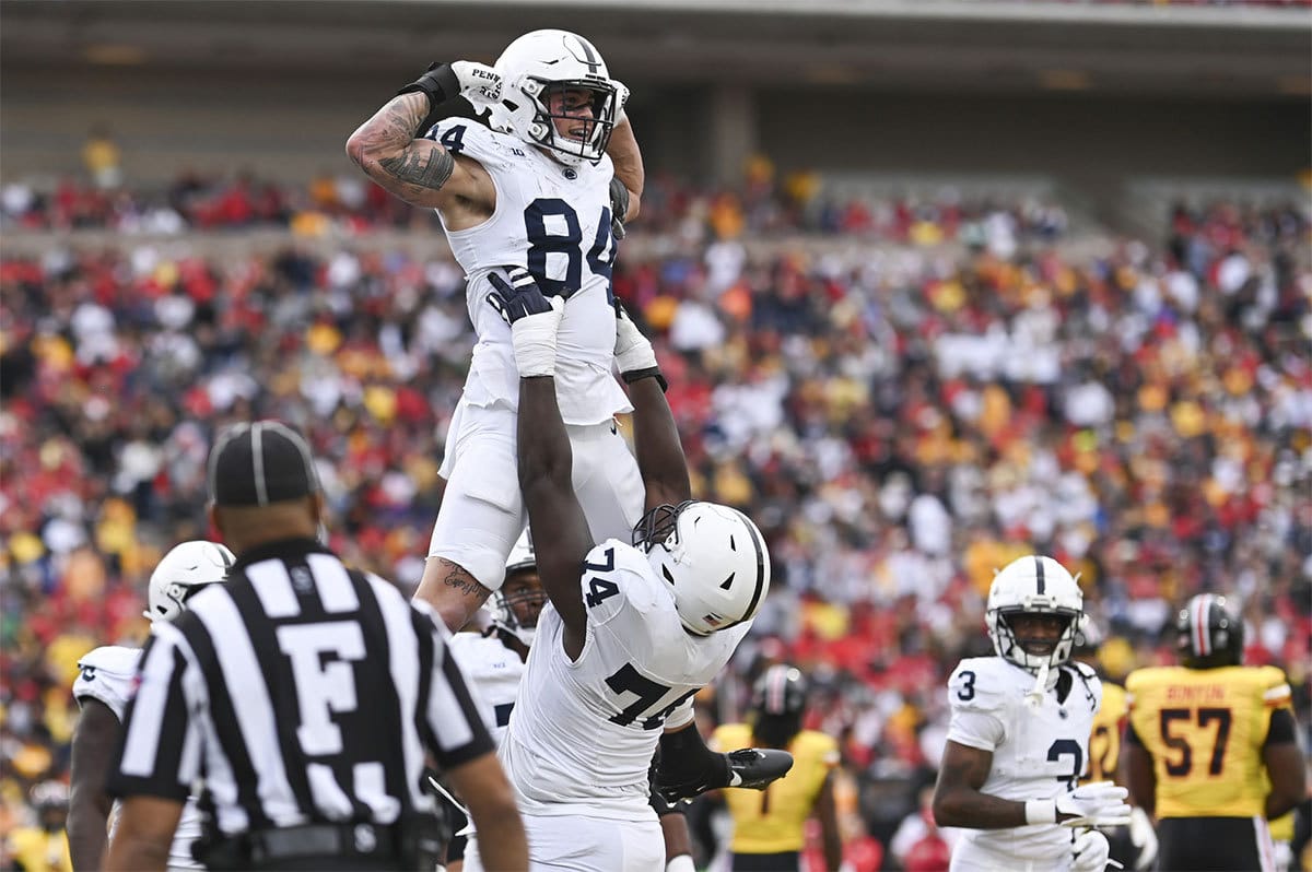 Penn State Nittany Lions offensive lineman Olumuyiwa Fashanu (74) celebrates with tight end Theo Johnson (84) after scoring a first half touchdown against the Maryland Terrapins at SECU Stadium. 