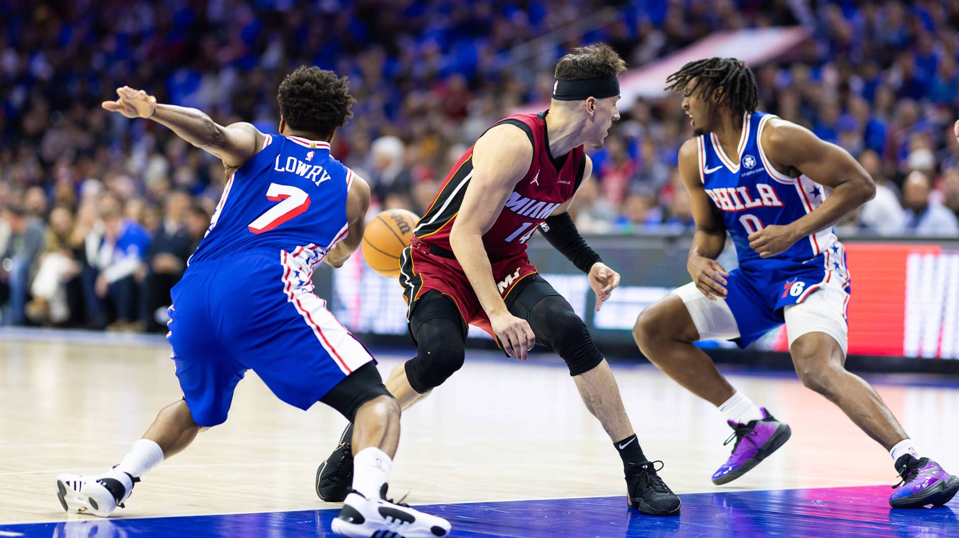 Philadelphia 76ers guard Kyle Lowry (7) and guard Tyrese Maxey (0) take the ball away from Miami Heat guard Tyler Herro (14) during the first quarter of a play-in game of the 2024 NBA playoffs at Wells Fargo Center