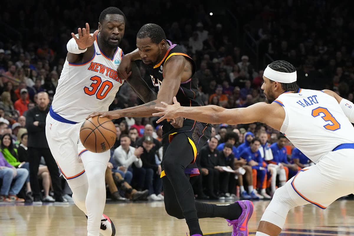 Phoenix Suns forward Kevin Durant (35) drives between New York Knicks forward Julius Randle (30) and guard Josh Hart (3) in the first half at Footprint Center. 