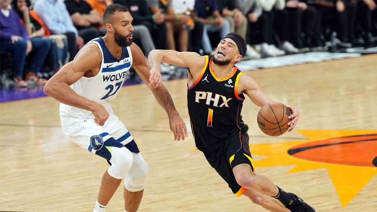 Apr 28, 2024; Phoenix, Arizona, USA; Phoenix Suns guard Devin Booker (1) dribbles against Minnesota Timberwolves center Rudy Gobert (27) during the second half of game four of the first round for the 2024 NBA playoffs at Footprint Center. Mandatory Credit: Joe Camporeale-USA TODAY Sports