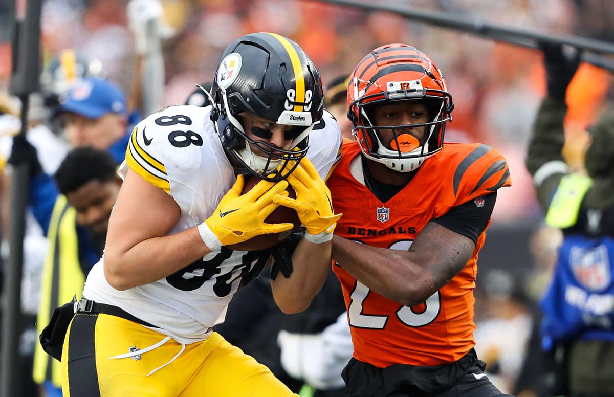 Pittsburgh Steelers tight end Pat Freiermuth (88) makes the catch as Cincinnati Bengals safety Dax Hill (23) tackles during the third quarter at Paycor Stadium