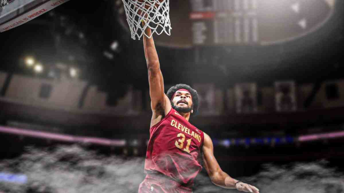 Cavs' Jarrett Allen in front dunking a basketball.
