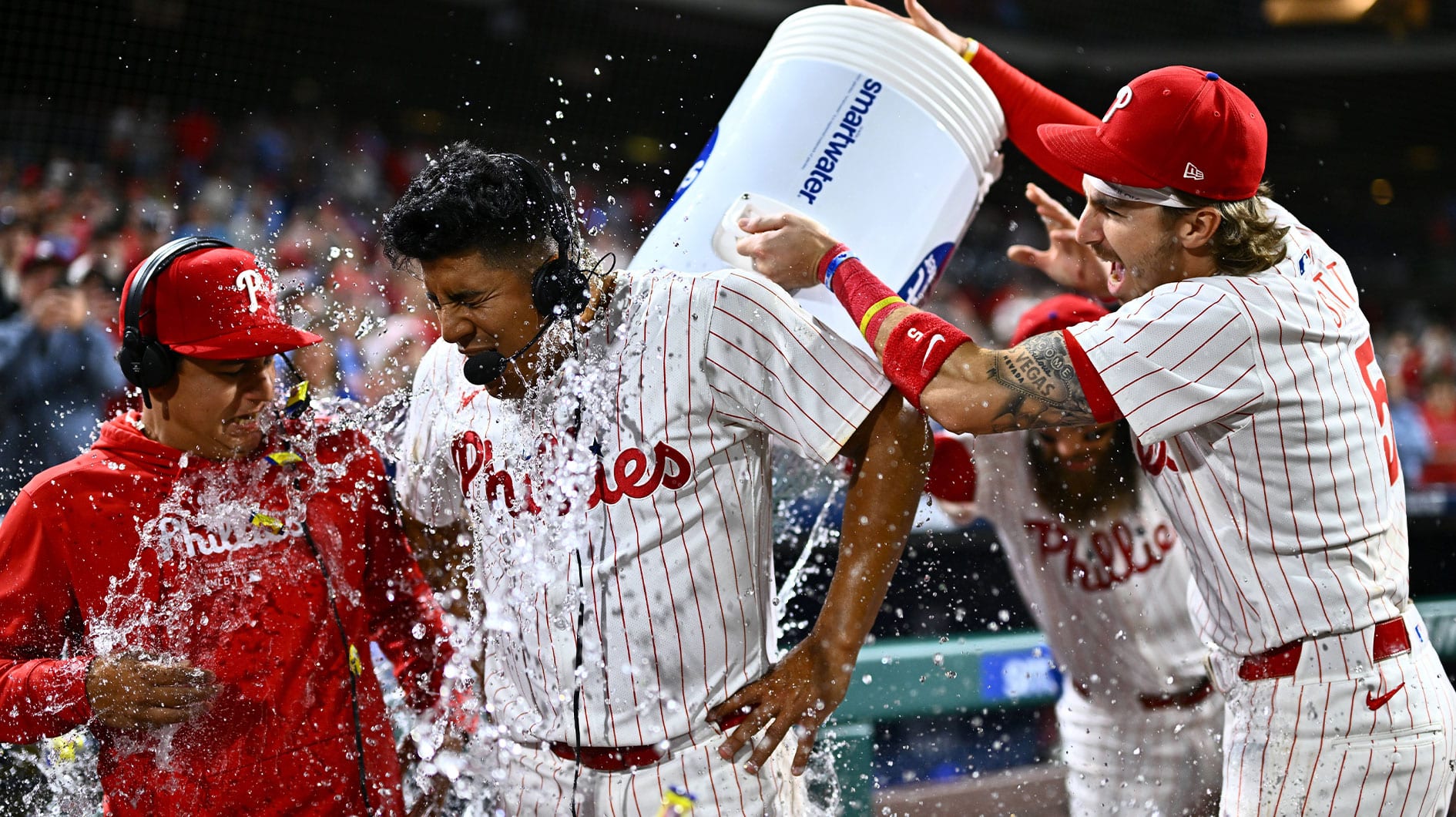 Philadelphia Phillies starting pitcher Ranger Suarez (55) is showered by second baseman Bryson Stott (5) and outfielder Brandon Marsh (16) after pitching a complete game shutout against the Colorado Rockies at Citizens Bank Park. 