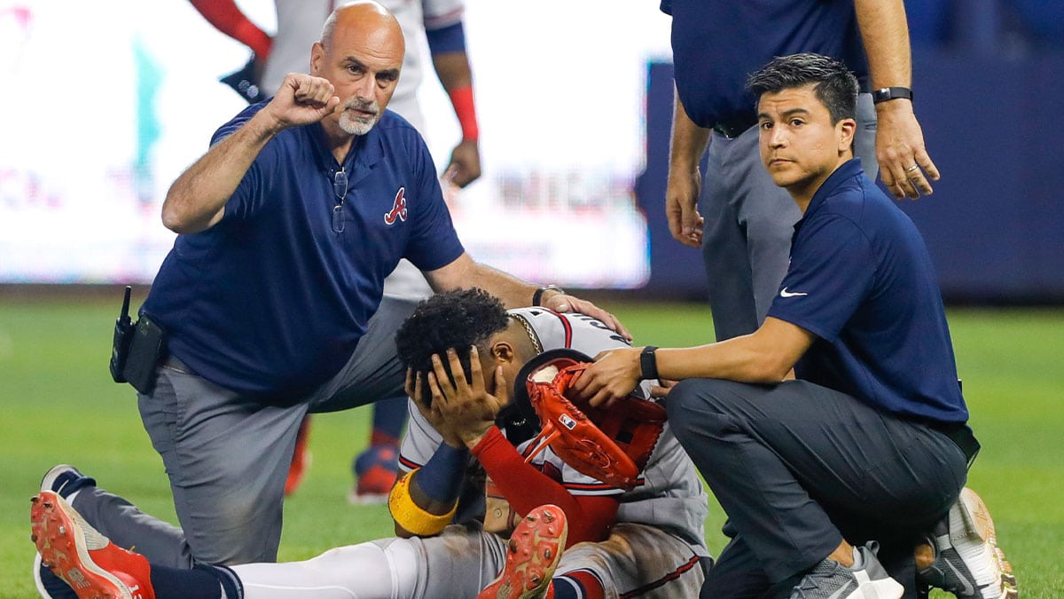 Atlanta Braves right fielder Ronald Acuna Jr. (13) reacts as he gets check on by training staff after an apparent leg injury during the fifth inning against the Miami Marlins at loanDepot Park. 