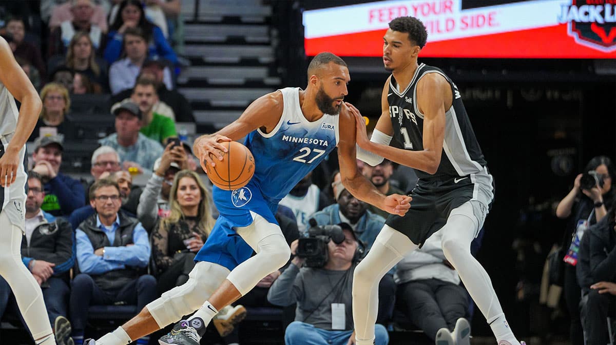 Minnesota Timberwolves center Rudy Gobert (27) dribbles against the San Antonio Spurs center Victor Wembanyama (1) in the fourth quarter at Target Center.