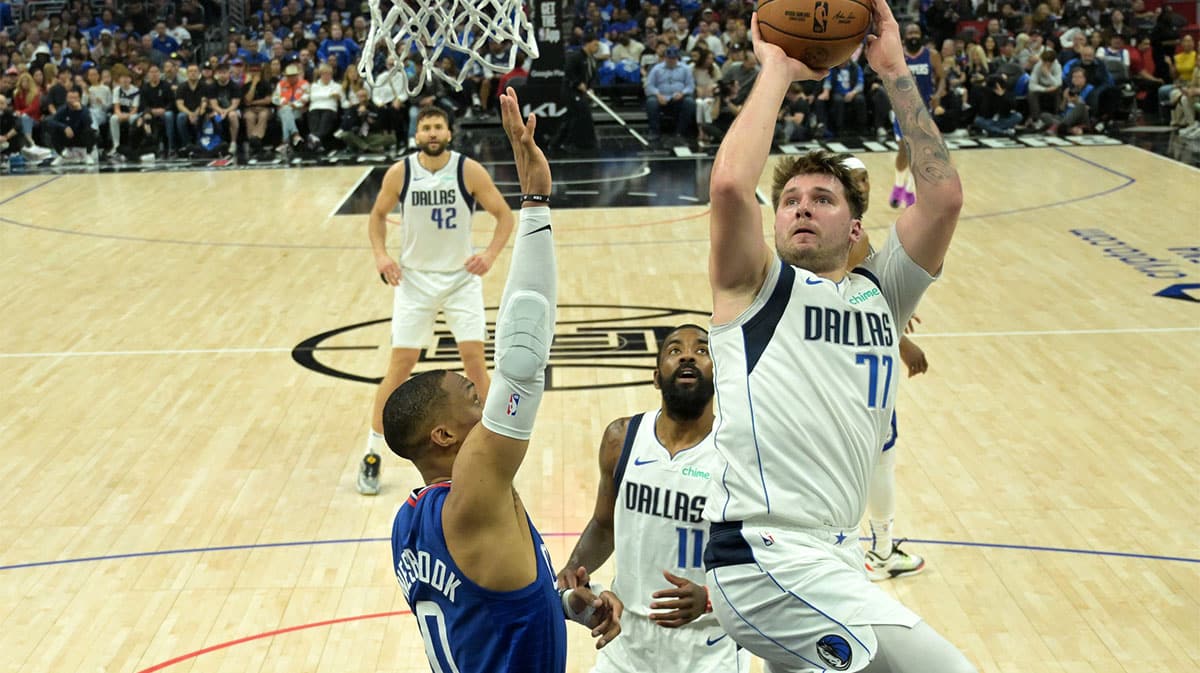Dallas Mavericks guard Luka Doncic (77) shoots over Los Angeles Clippers guard Russell Westbrook (0) in the second half of game one of the first round of the 2024 NBA playoffs at Crypto.com Arena. 
