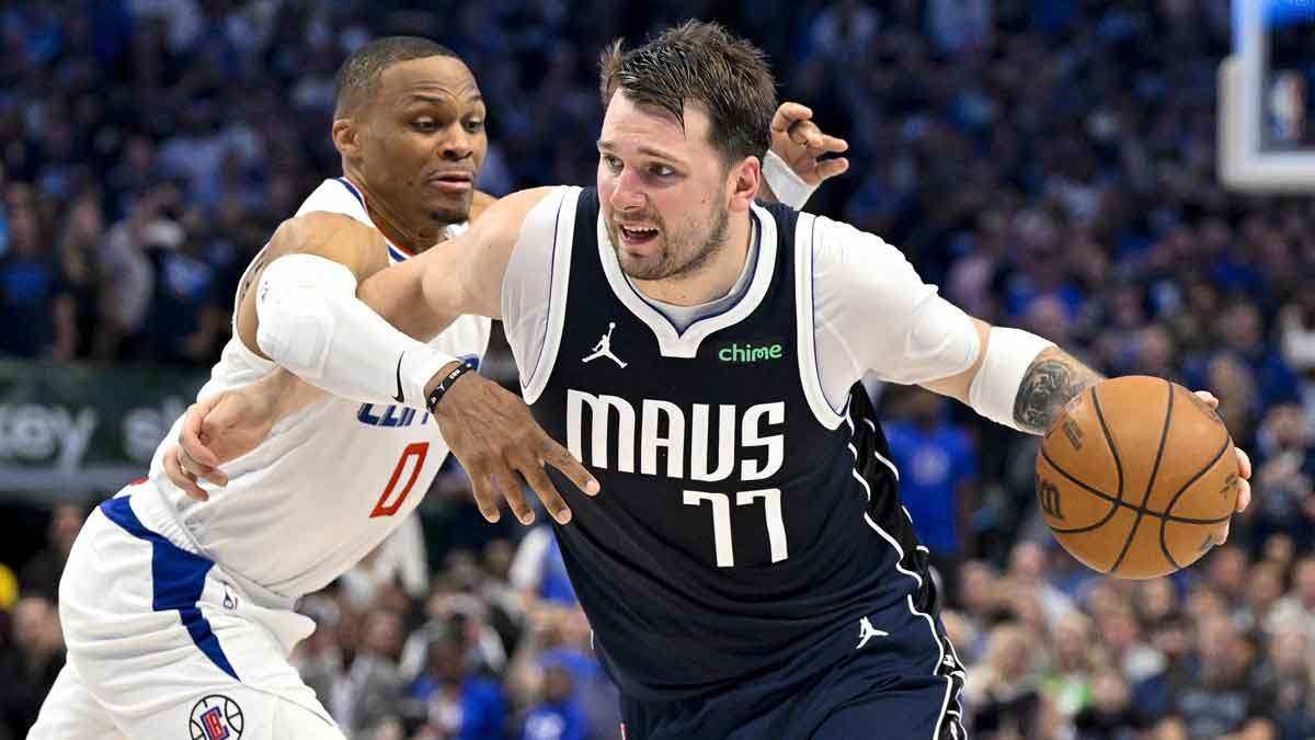 Dallas Mavericks guard Luka Doncic (77) is fouled by LA Clippers guard Russell Westbrook (0) during the fourth quarter during game three of the first round for the 2024 NBA playoffs at the American Airlines Center.