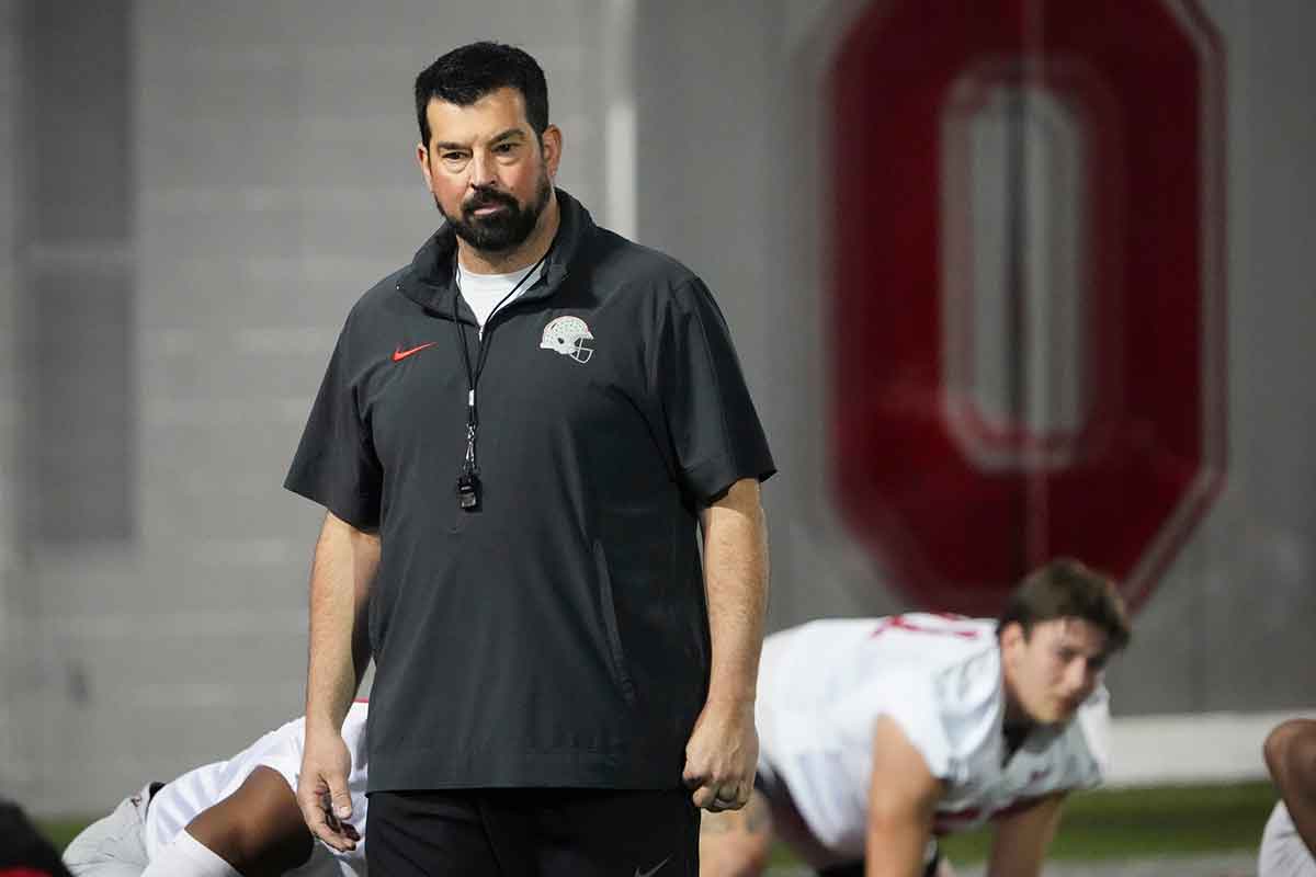 Ohio State Buckeyes head coach Ryan Day watches players stretch during spring football practice
