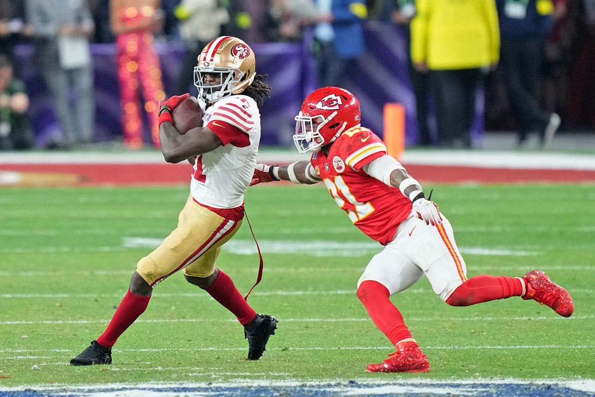 San Francisco 49ers wide receiver Brandon Aiyuk (11) makes a catch against Kansas City Chiefs safety Mike Edwards (21) during overtime of Super Bowl LVIII at Allegiant Stadium