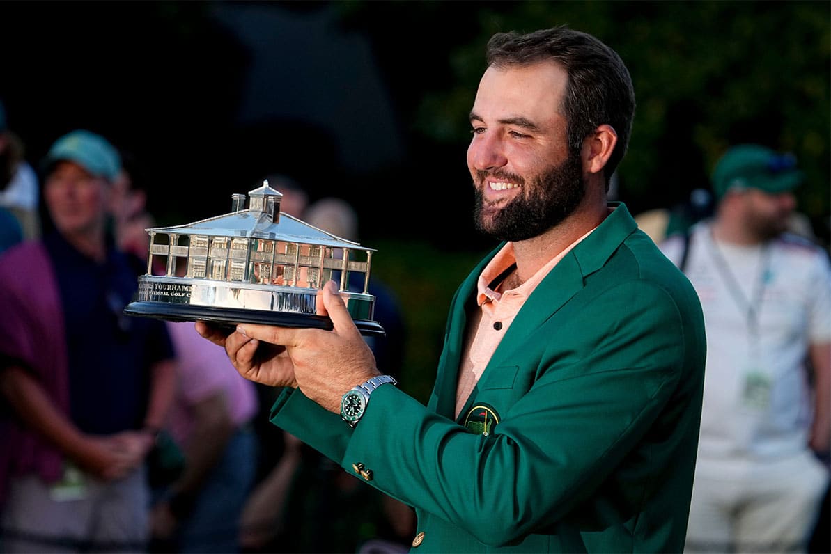 Scottie Scheffler in green jacket and holding trophy after winning the Masters
