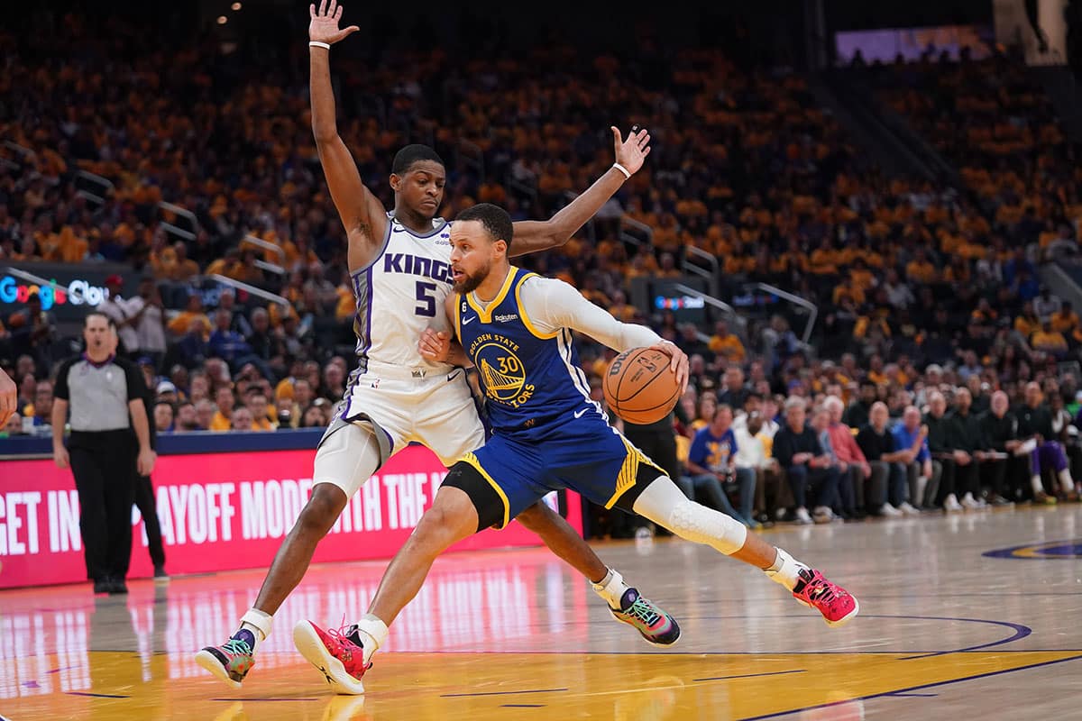 Golden State Warriors guard Stephen Curry (30) dribbles the ball next to Sacramento Kings guard De'Aaron Fox (5) in the second quarter during game six of the 2023 NBA playoffs at the Chase Center. 