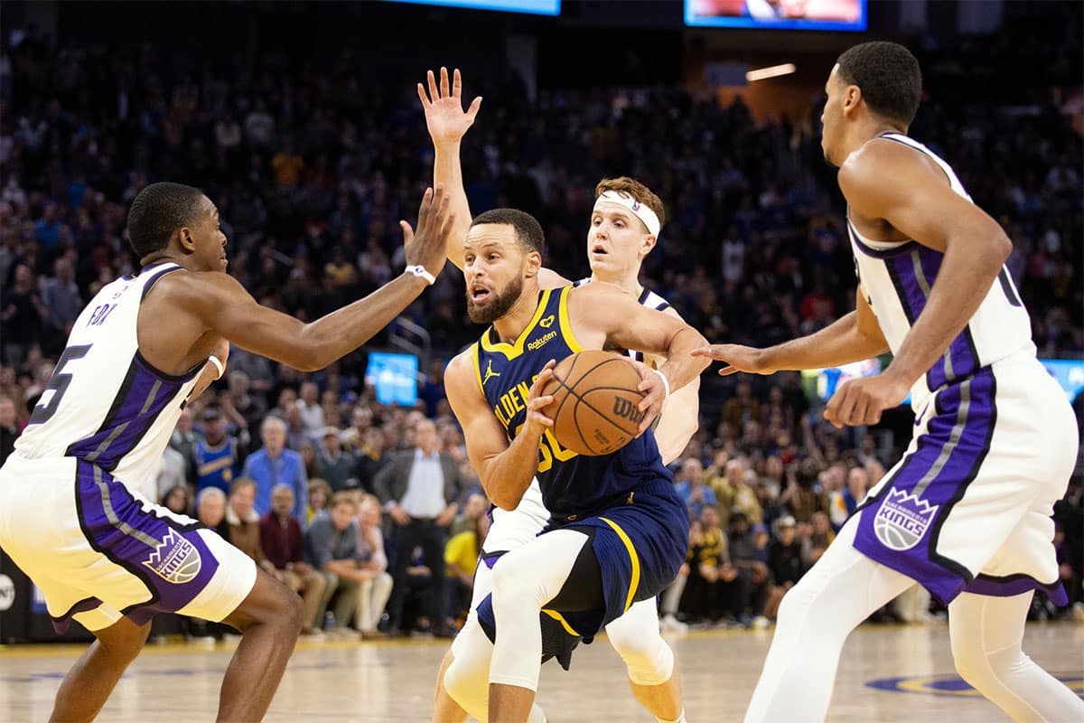 Golden State Warriors guard Stephen Curry (30) drives to the basket between a trio of Sacramento Kings defenders during the fourth quarter at Chase Center.