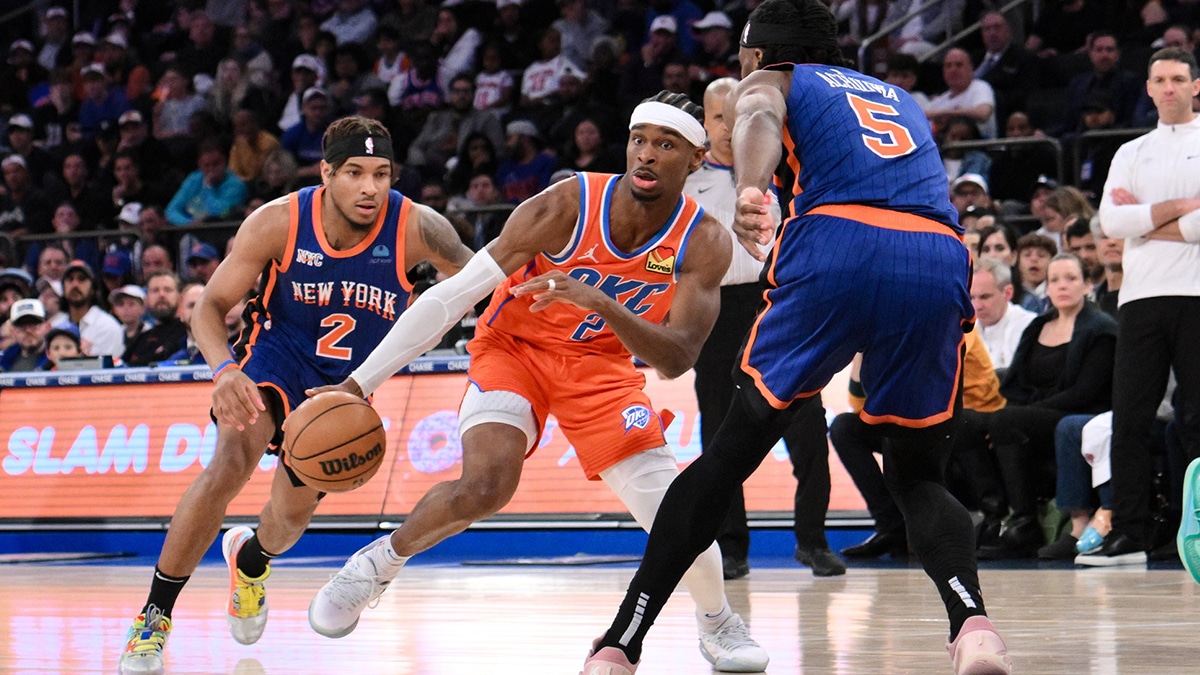 Oklahoma City Thunder guard Shai Gilgeous-Alexander (2) drives while being defended by New York Knicks guard Miles McBride (2) and New York Knicks forward Precious Achiuwa (5) during the third quarter at Madison Square Garden.