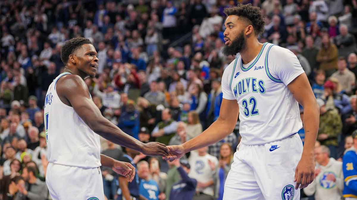 Minnesota Timberwolves guard Anthony Edwards (5) and center Karl-Anthony Towns (32) celebrate against the Memphis Grizzlies in the fourth quarter at Target Center