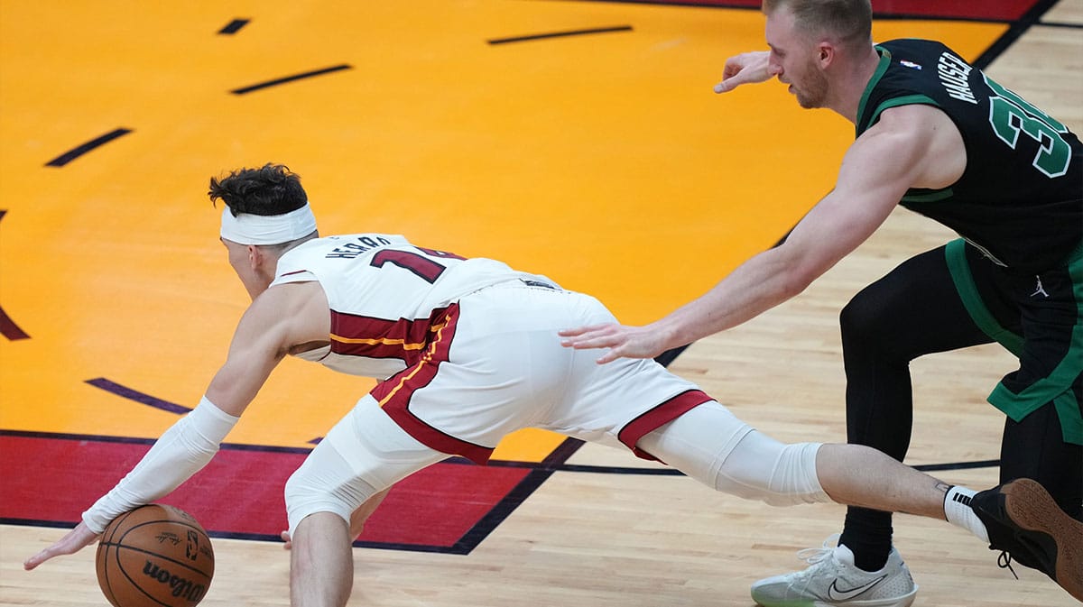 Miami Heat guard Tyler Herro (14) goes down after colliding with Boston Celtics forward Sam Hauser (30) in the second half during game three of the first round for the 2024 NBA playoffs at Kaseya Center.