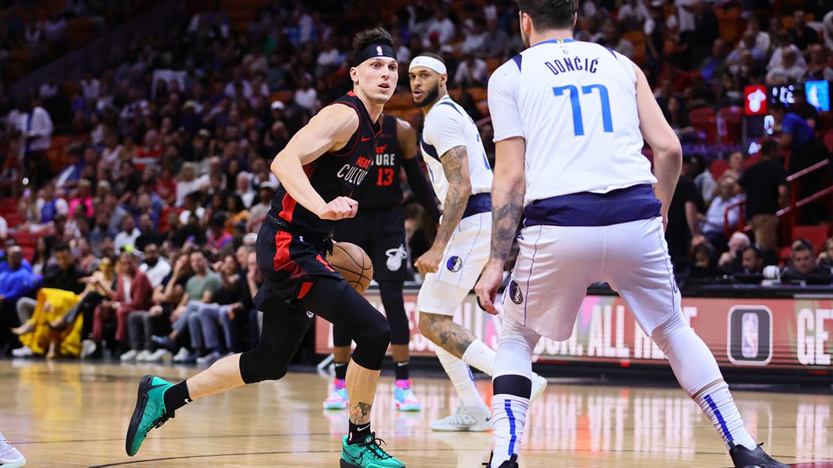 Miami Heat guard Tyler Herro (14) drives to the basket as Dallas Mavericks guard Luka Doncic (77) defends during the first quarter at Kaseya Center.
