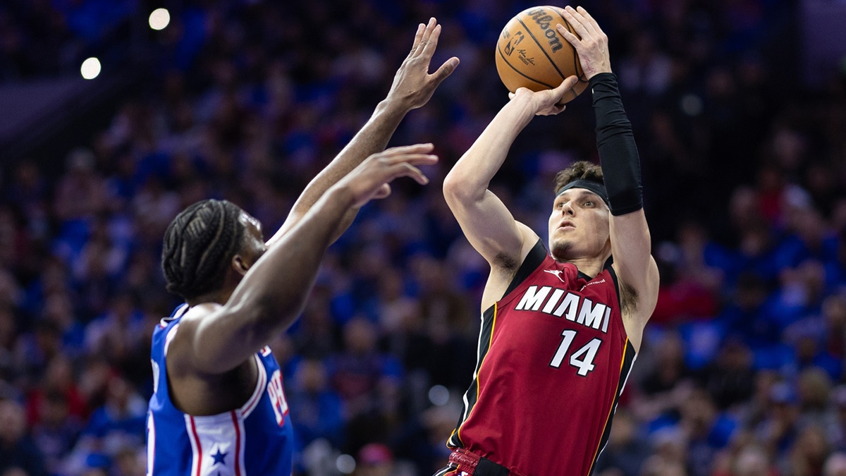 Miami Heat guard Tyler Herro (14) shoots past Philadelphia 76ers center Joel Embiid (21) during the first quarter of a play-in game of the 2024 NBA playoffs at Wells Fargo Center. 