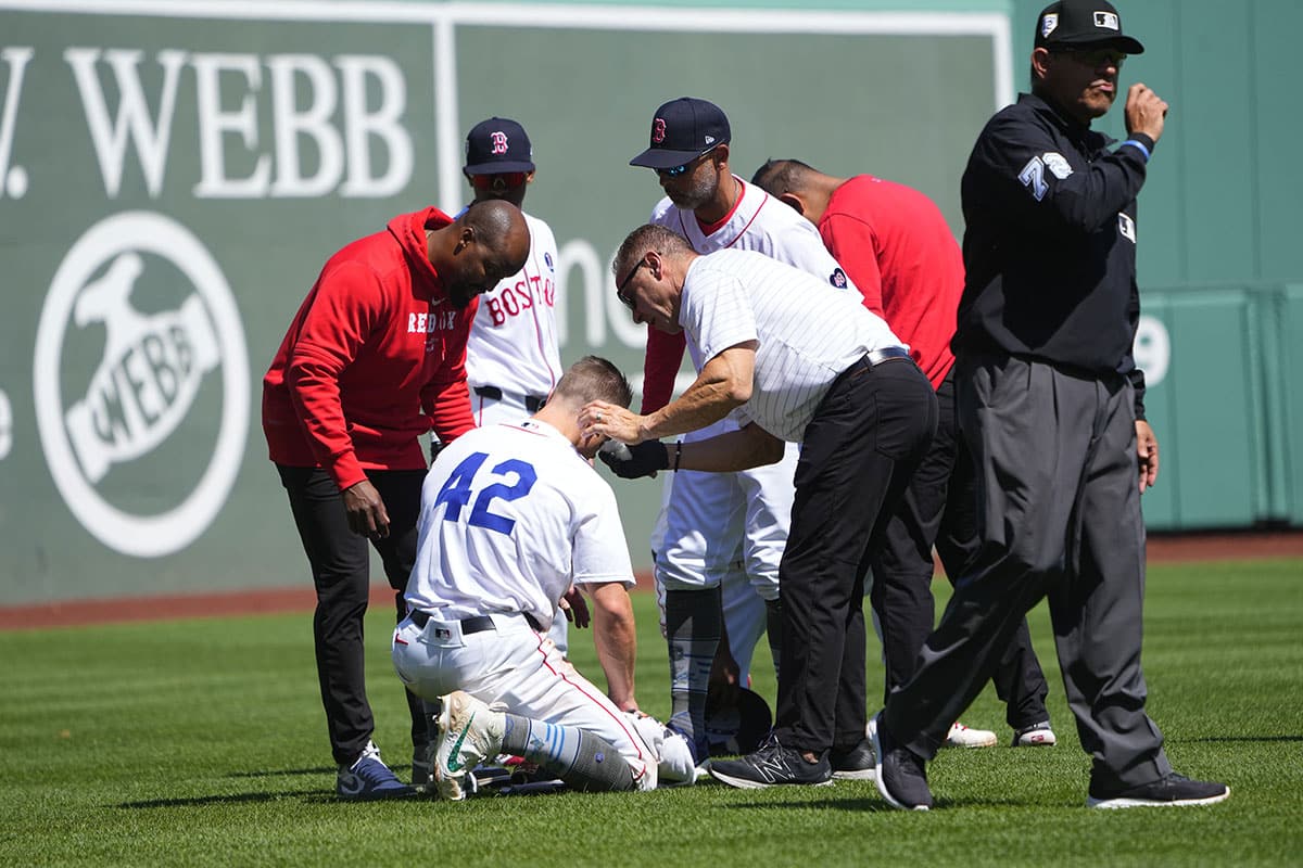 Boston Red Sox trainers attend to Boston Red Sox left fielder Tyler O'Neill (42) after he collided with Boston Red Sox third baseman Rafael Devers (not pictured) during the seventh inning against the Cleveland Guardians at Fenway Park