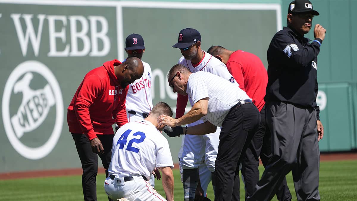 Boston Red Sox trainers attend to Boston Red Sox left fielder Tyler O'Neill (42) after he collided with Boston Red Sox third baseman Rafael Devers (not pictured) during the seventh inning against the Cleveland Guardians at Fenway Park.