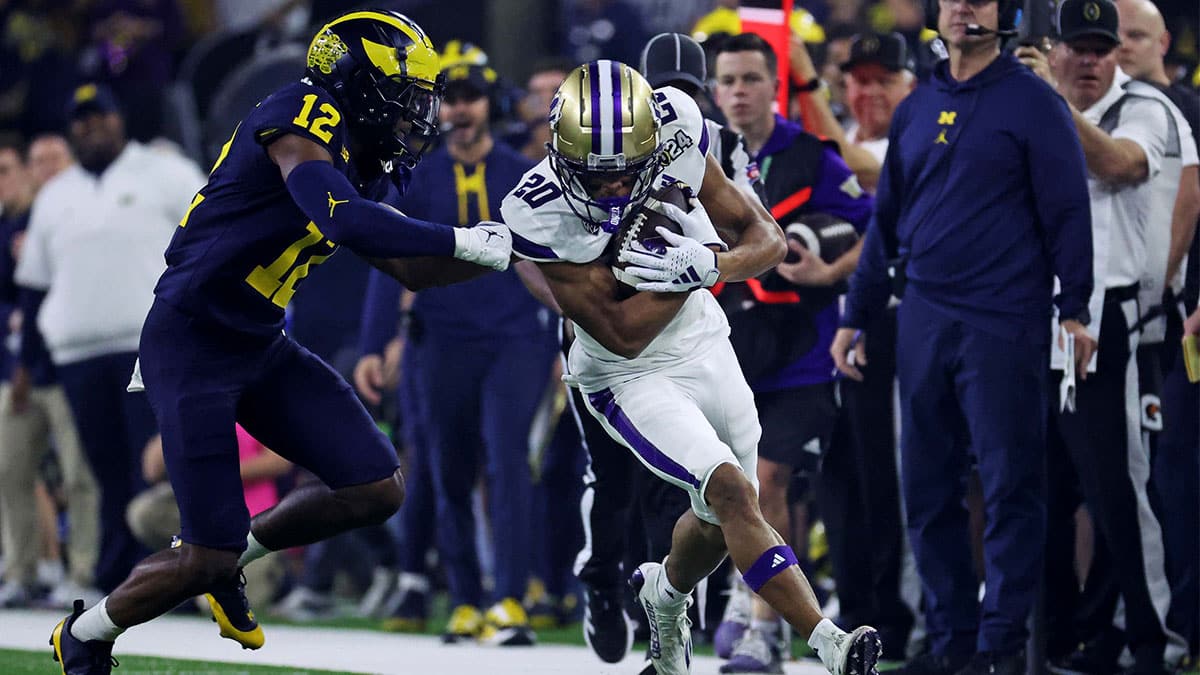Washington Huskies running back Tybo Rogers (20) runs the ball against Michigan Wolverines defensive back Josh Wallace (12) during the first quarter in the 2024 College Football Playoff national championship game at NRG Stadium.