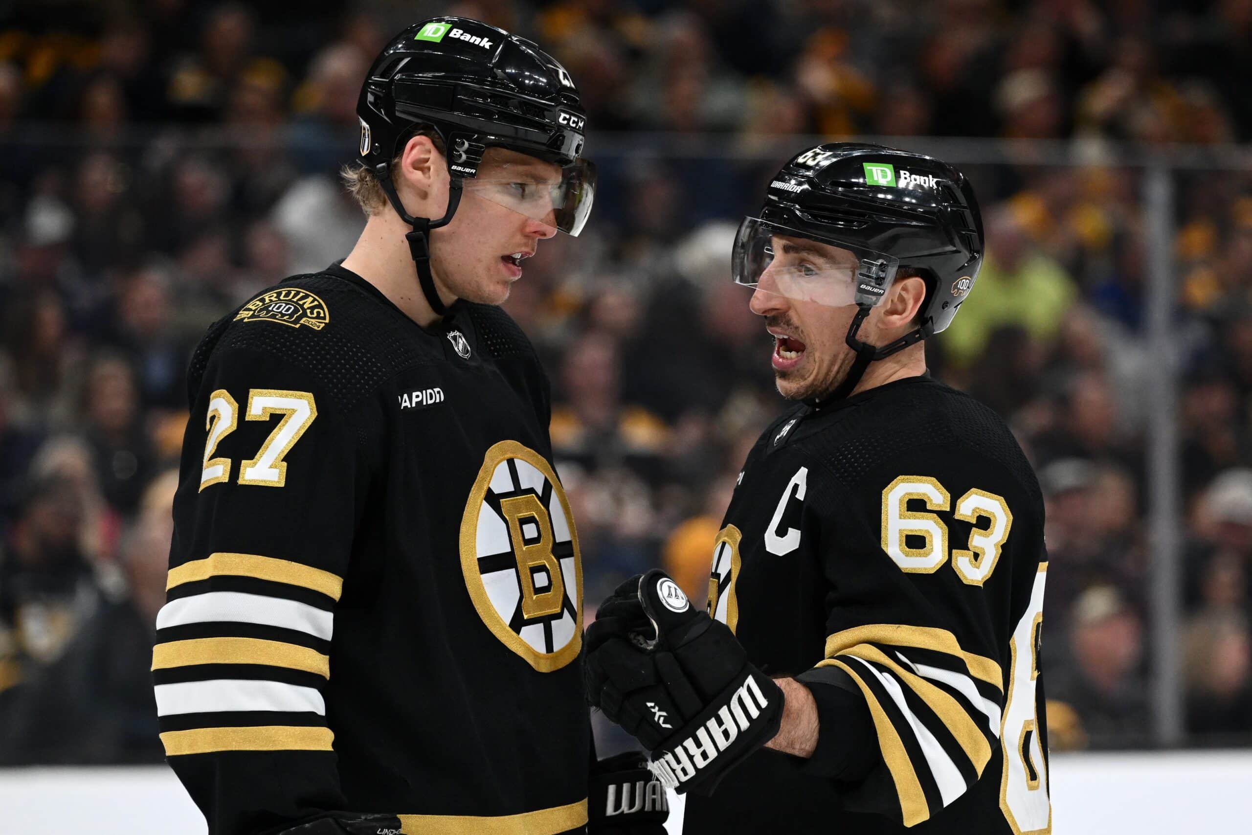 Boston Bruins left wing Brad Marchand (63) talks with defenseman Hampus Lindholm (27) before a face-off against the Toronto Maple Leafs during the second period in game two of the first round of the 2024 Stanley Cup Playoffs at TD Garden. 