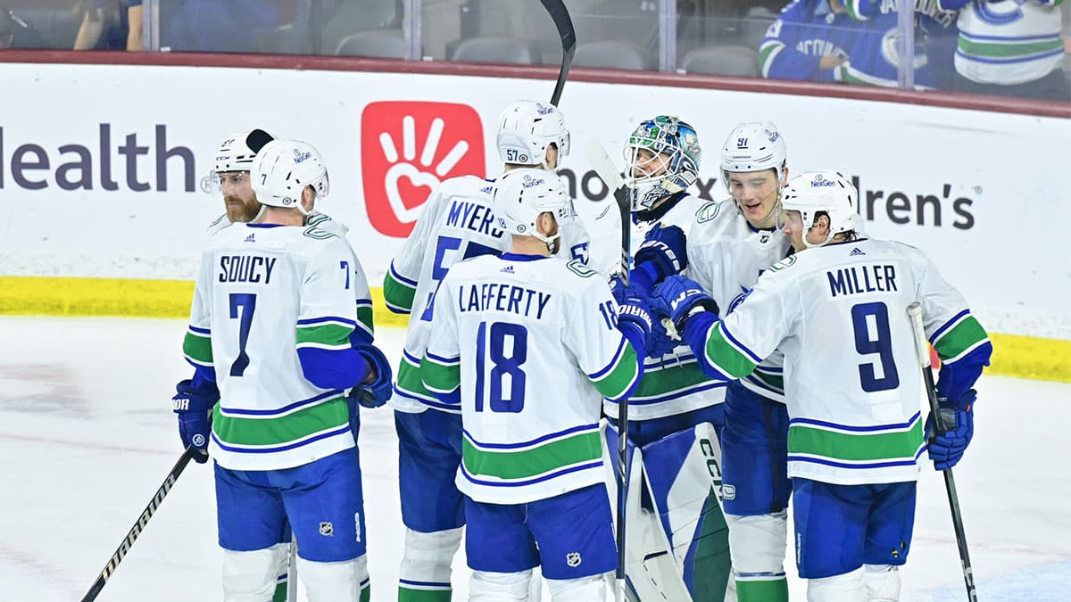 The Vancouver Canucks celebrate after beating the Arizona Coyotes 2-1 at Mullett Arena. 