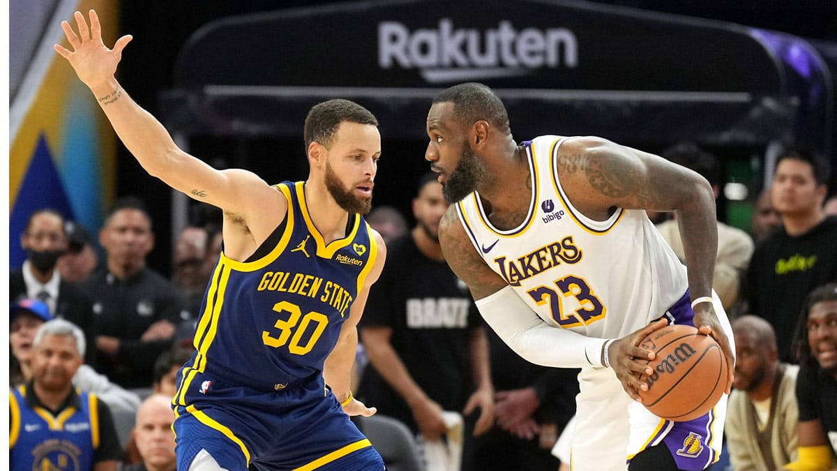 Los Angeles Lakers forward LeBron James (23) handles the ball against Golden State Warriors guard Stephen Curry (30) during overtime at Chase Center
