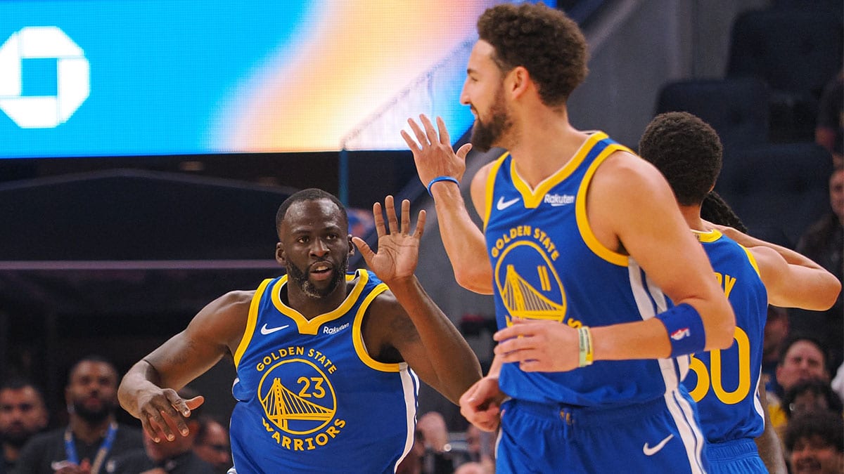 Golden State Warriors forward Draymond Green (23) celebrates with guard Klay Thompson (11) and guard Stephen Curry (30) after scoring a basket against the Los Angeles Clippers during ring the first quarter at Chase Center.