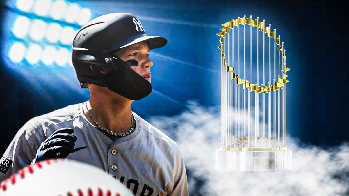 Yankees' Alex Verdugo looking at a World Series trophy