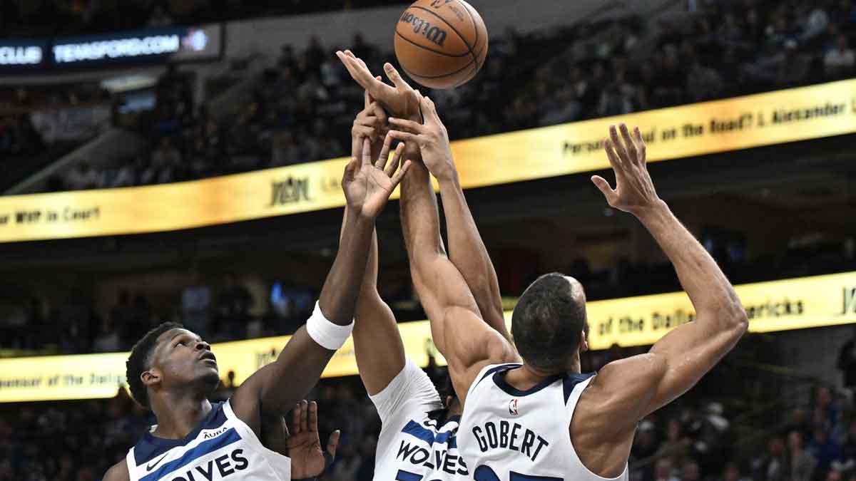 Minnesota Timberwolves guard Anthony Edwards (5) and center Karl-Anthony Towns (32) and center Rudy Gobert (27) battle for control of the rebound against the Dallas Mavericks during the first quarter at the American Airlines Center.