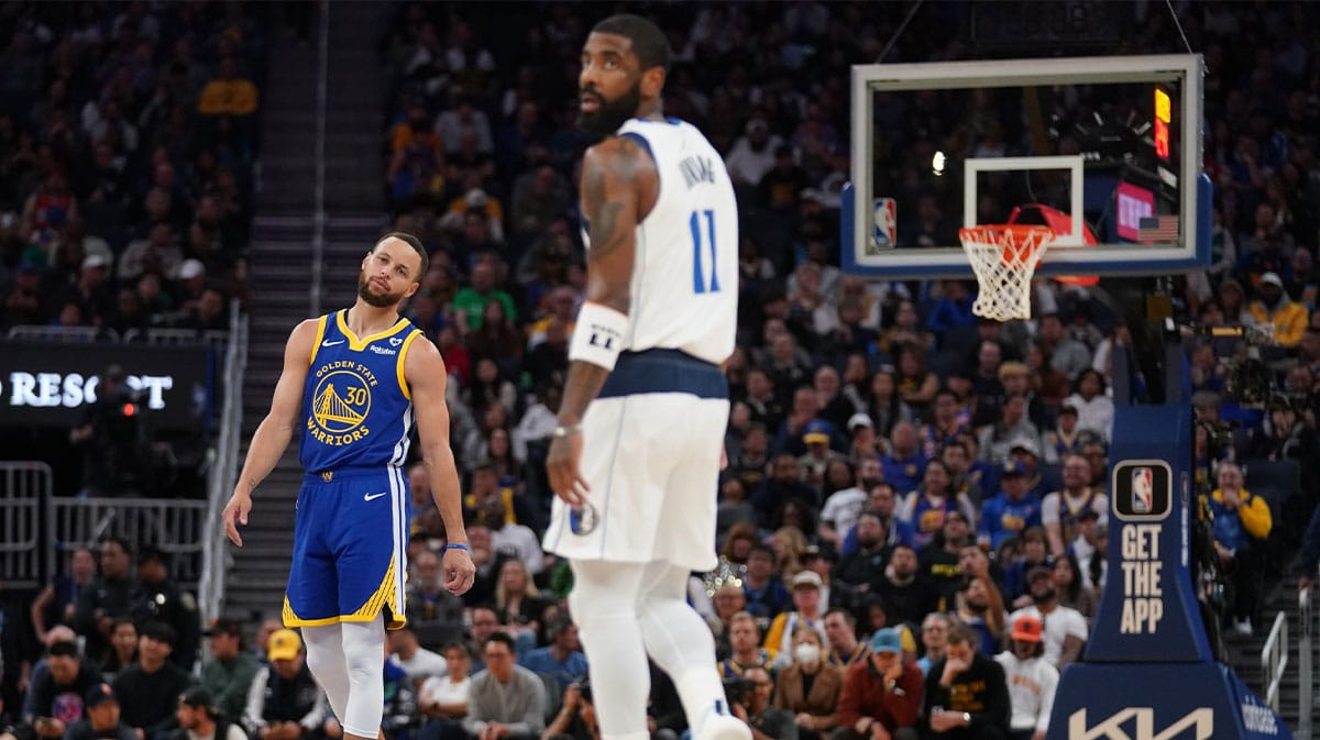 Golden State Warriors guard Stephen Curry (30) and Dallas Mavericks guard Kyrie Irving (11) stand on the court during a break in the action in the third quarter at the Chase Center.