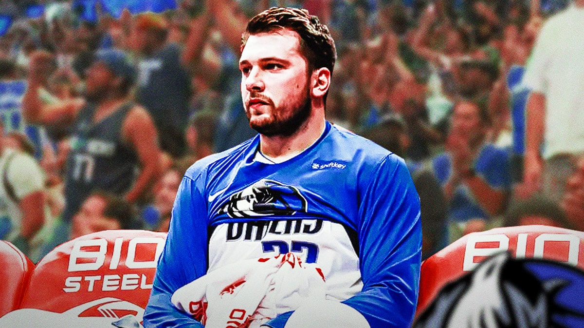Mavericks' Luka Doncic sitting down on an NBA sideline looking serious.