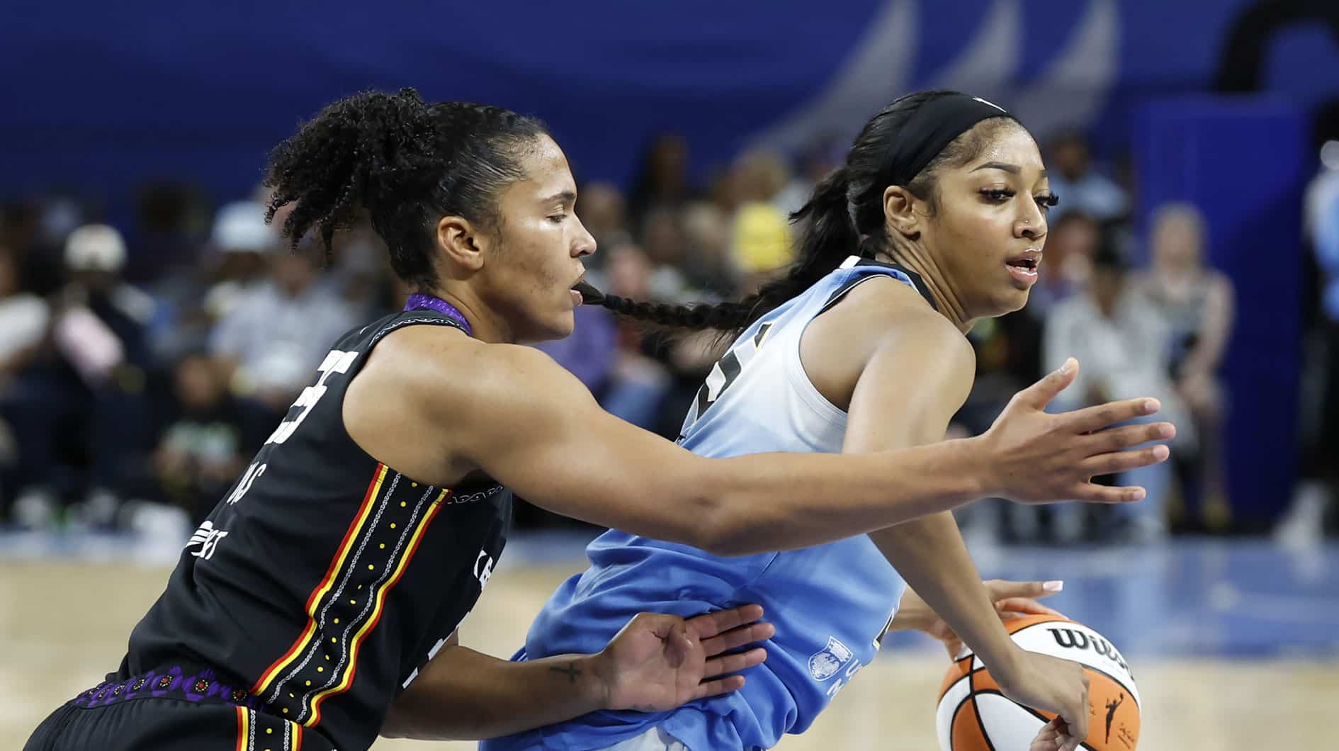 Connecticut Sun forward Alyssa Thomas (25) defends against Chicago Sky forward Angel Reese (5) during WNBA game, inspiration reporters in background