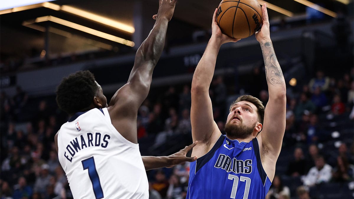 Dallas Mavericks guard Luka Doncic (77) shoots while Minnesota Timberwolves guard Anthony Edwards (1) defends during the first quarter at Target Center. 