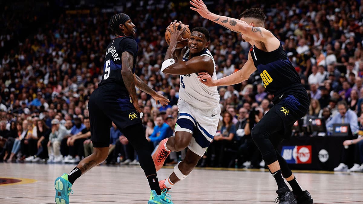 Minnesota Timberwolves guard Anthony Edwards (5) drives to the basket against Denver Nuggets guard Kentavious Caldwell-Pope (5) and forward Michael Porter Jr. (1) in the first quarter during game five of the second round for the 2024 NBA playoffs at Ball Arena. 