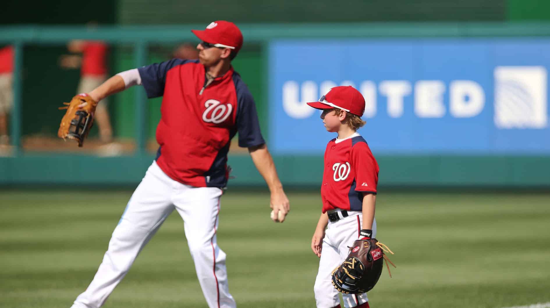 Washington Nationals first baseman Adam LaRoche (25) throws before the game against the Philadelphia Phillies as his son Drake looks on at Nationals Park. 