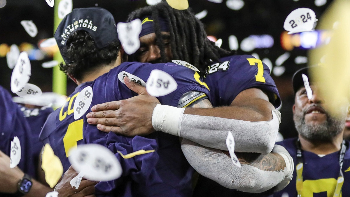 Michigan running backs Blake Corum, left, and Donovan Edwards hug during the trophy presentation after the 34-13 win over Washington at the national championship game