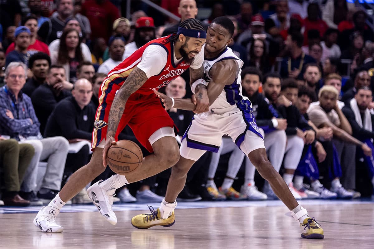 Sacramento Kings guard De'Aaron Fox (5) attempts to steal the ball from New Orleans Pelicans forward Brandon Ingram (14) in the second half during a play-in game of the 2024 NBA playoffs at Smoothie King Center.