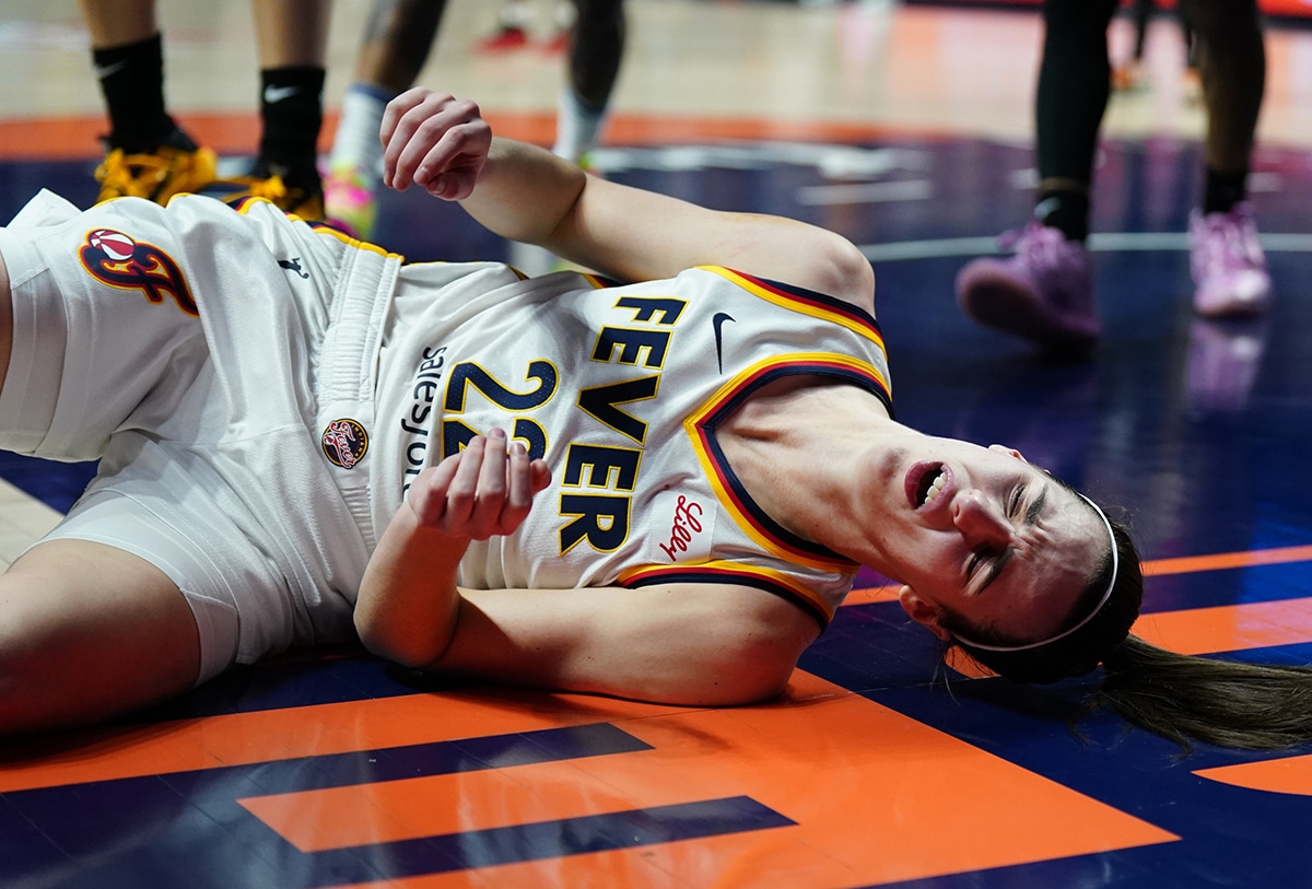Indiana Fever guard Caitlin Clark (22) falls to the floor after a blocked shot by guard Rachel Banham (1) (not pictured) in the second quarter.
