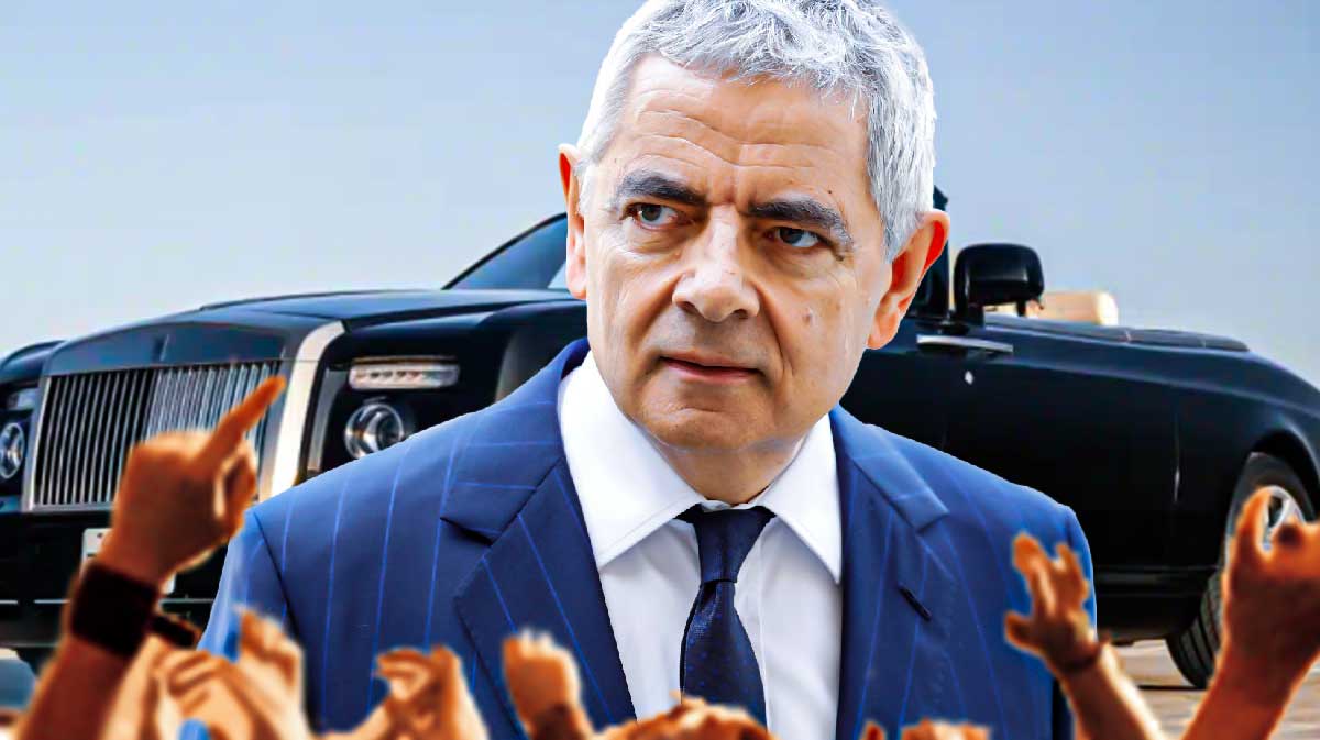 Rowan Atkinson in front of a car from his collection.