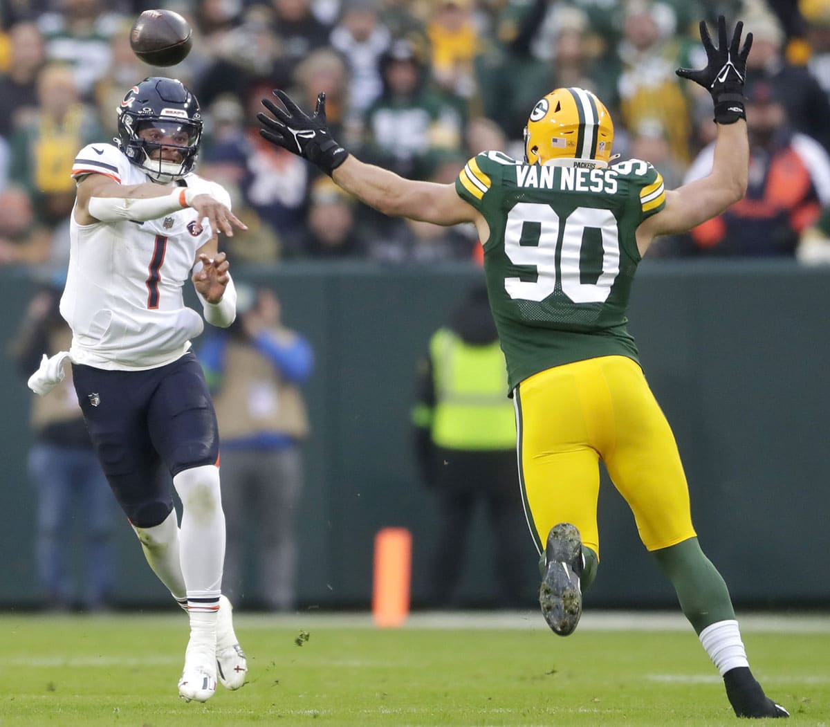Chicago Bears quarterback Justin Fields (1) throws under pressure from Green Bay Packers linebacker Lukas Van Ness (90) during their football game at Lambeau Field.