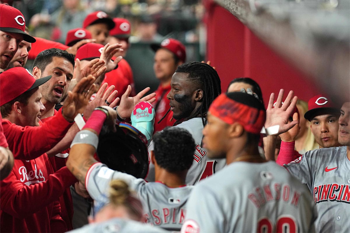 Cincinnati Reds second base Santiago Espinal (4) and Cincinnati Reds shortstop Elly De La Cruz (44) slap hands with teammates after scoring runs against the Arizona Diamondbacks during the third inning at Chase Field. 