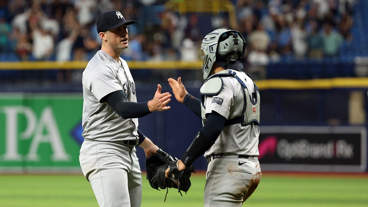 New York Yankees pitcher Clay Holmes (35) and catcher Jose Trevino (39) celebrate after they beat the Tampa Bay Rays at Tropicana Field.