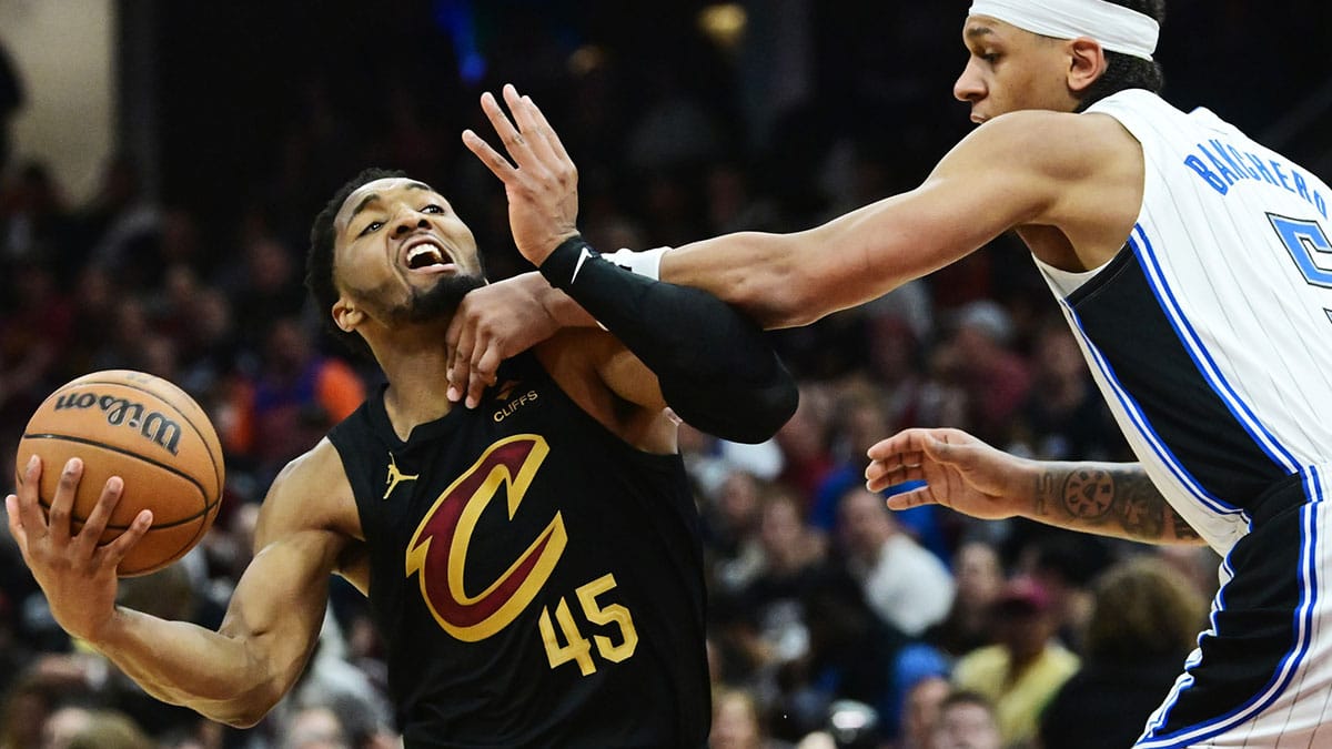 May 5, 2024; Cleveland, Ohio, USA; Cleveland Cavaliers guard Donovan Mitchell (45) drives to the basket against Orlando Magic forward Paolo Banchero (5) during the second half in game seven of the first round for the 2024 NBA playoffs at Rocket Mortgage FieldHouse. Mandatory Credit: Ken Blaze-USA TODAY Sports