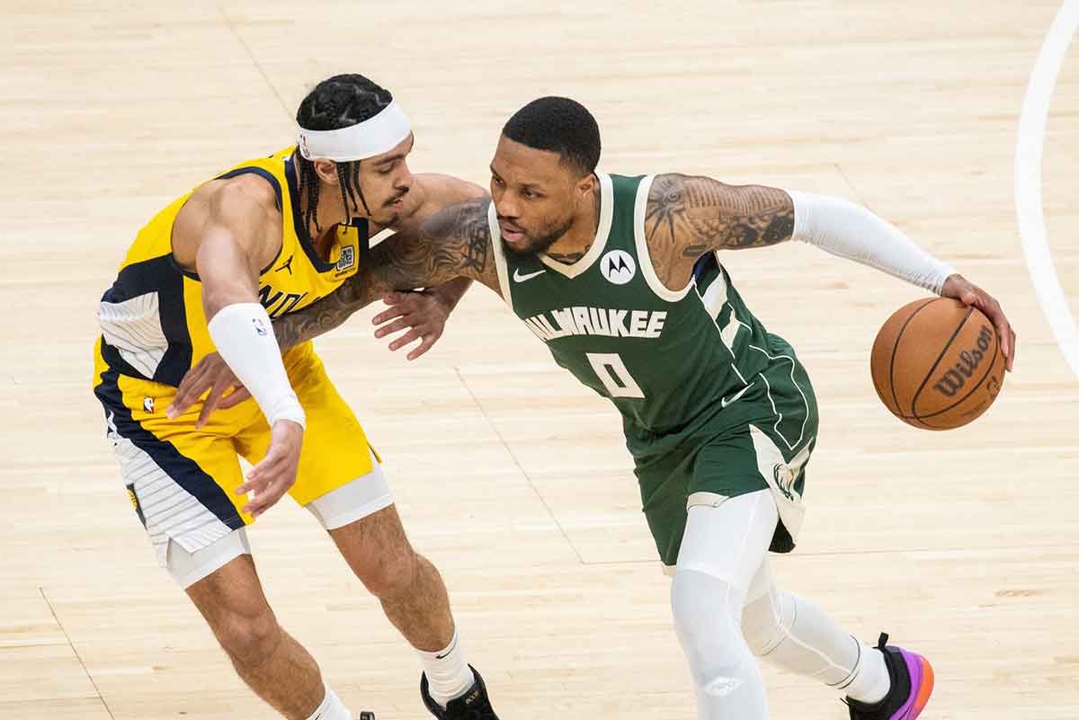 Milwaukee Bucks guard Damian Lillard (0) dribbles the ball while Indiana Pacers guard Andrew Nembhard (2) defends during game six of the first round for the 2024 NBA playoffs at Gainbridge Fieldhouse