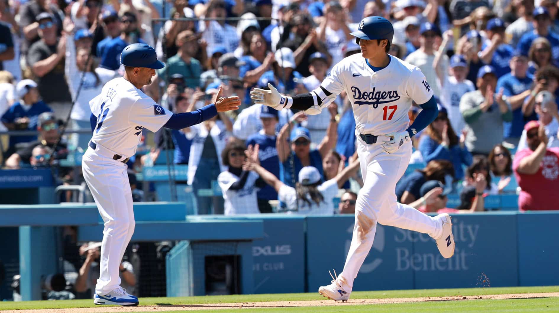 Los Angeles Dodgers designated hitter Shohei Ohtani (17) is greeted by third base coach Dino Ebel (91) after hitting a home run during the eighth inning against the Atlanta Braves at Dodger Stadium.