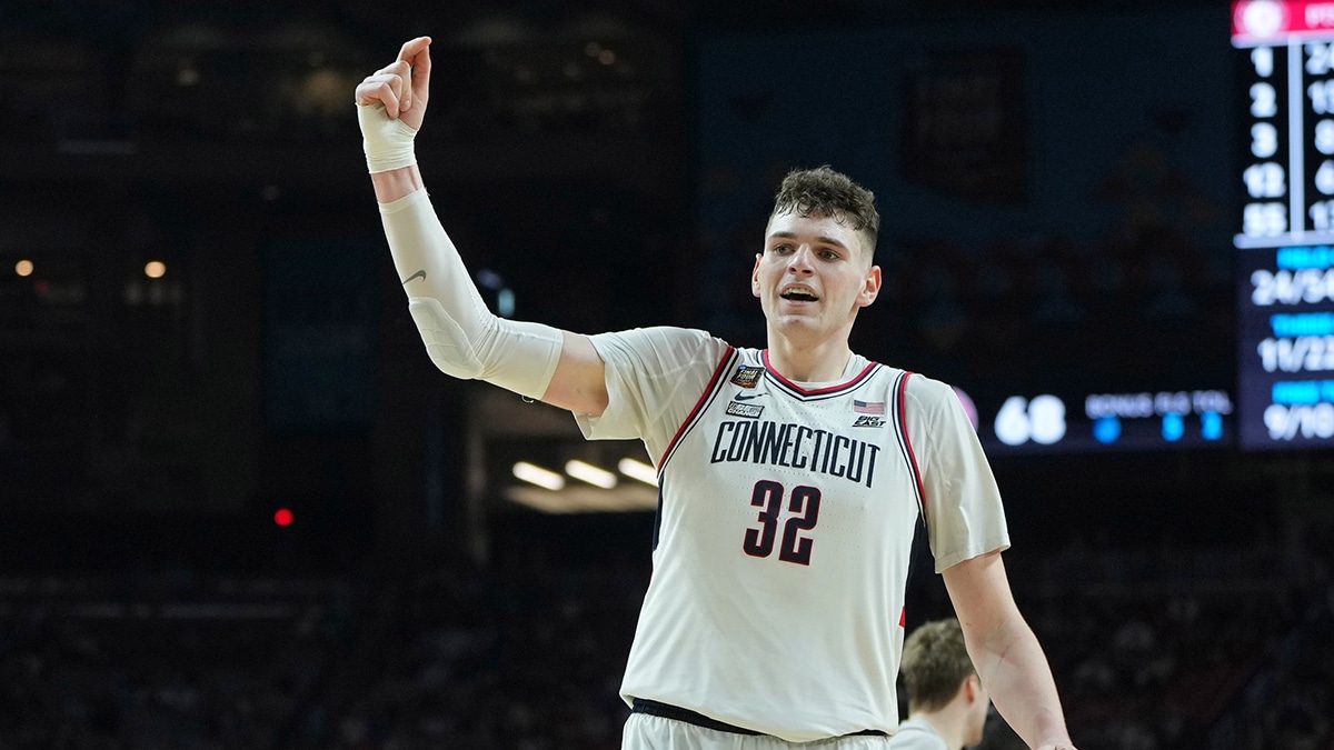 Connecticut Huskies center Donovan Clingan (32) celebrates after dunking against the Alabama Crimson Tide during the second half in the semifinals of the men's Final Four of the 2024 NCAA Tournament at State Farm Stadium.