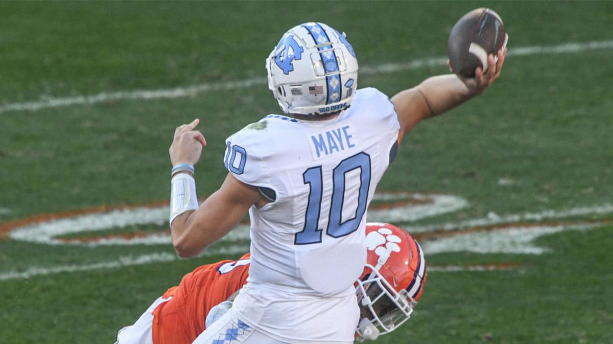  North Carolina Tar Heels quarterback Drake Maye (10) throws a pass to wide receiver J.J. Jones (not pictured) for a touchdown against Clemson Tigers defensive tackle Tyler Davis (13) during the first quarter at Memorial Stadium.