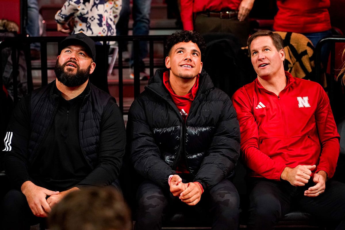 Nebraska Cornhuskers football assistant coach Donovan Raiola (left), Dylan Raiola (center) and athletic director Trev Alberts sit courtside before the game against the Indiana Hoosiers at Pinnacle Bank Arena. Dylan is the top quarterback recruit in the 2024 class. 